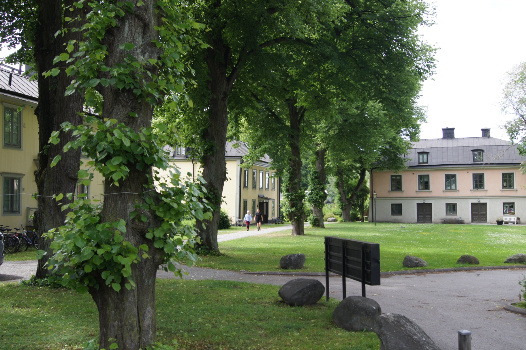 Gårdsmiljö med allé och äldre byggnader vid Sundsta gård i Årsta